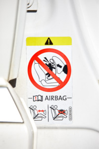 Symbol som viser at det er ulovlig å ha bakovervendt bilstol foran aktiv airbag, 