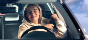 Bilde av ung dame som kjører bil med bilbelte på